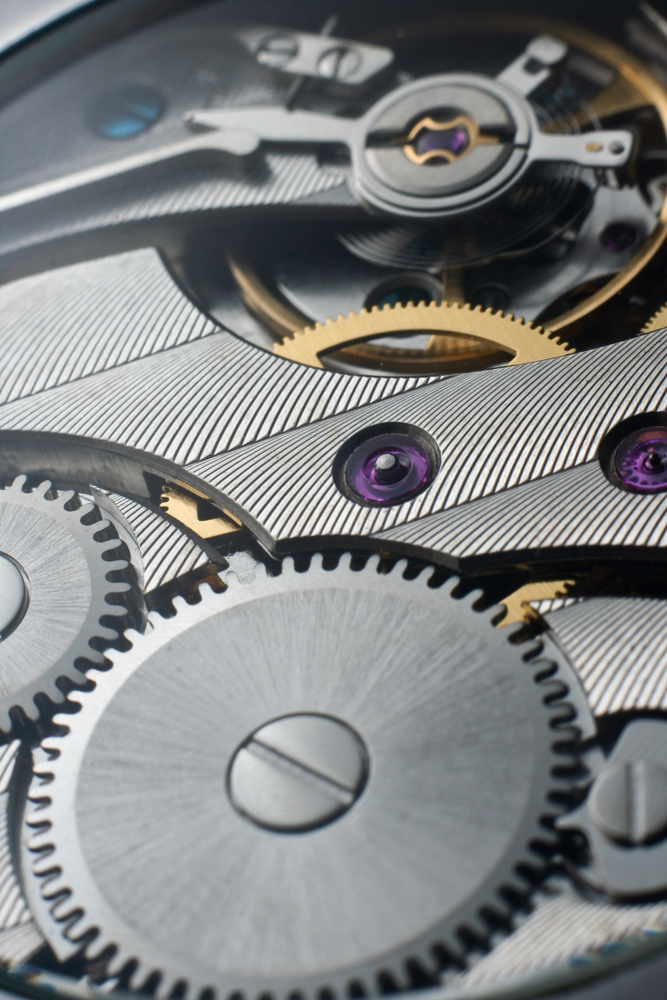 Macro of a watch movement with striped bridges and ruby jewels